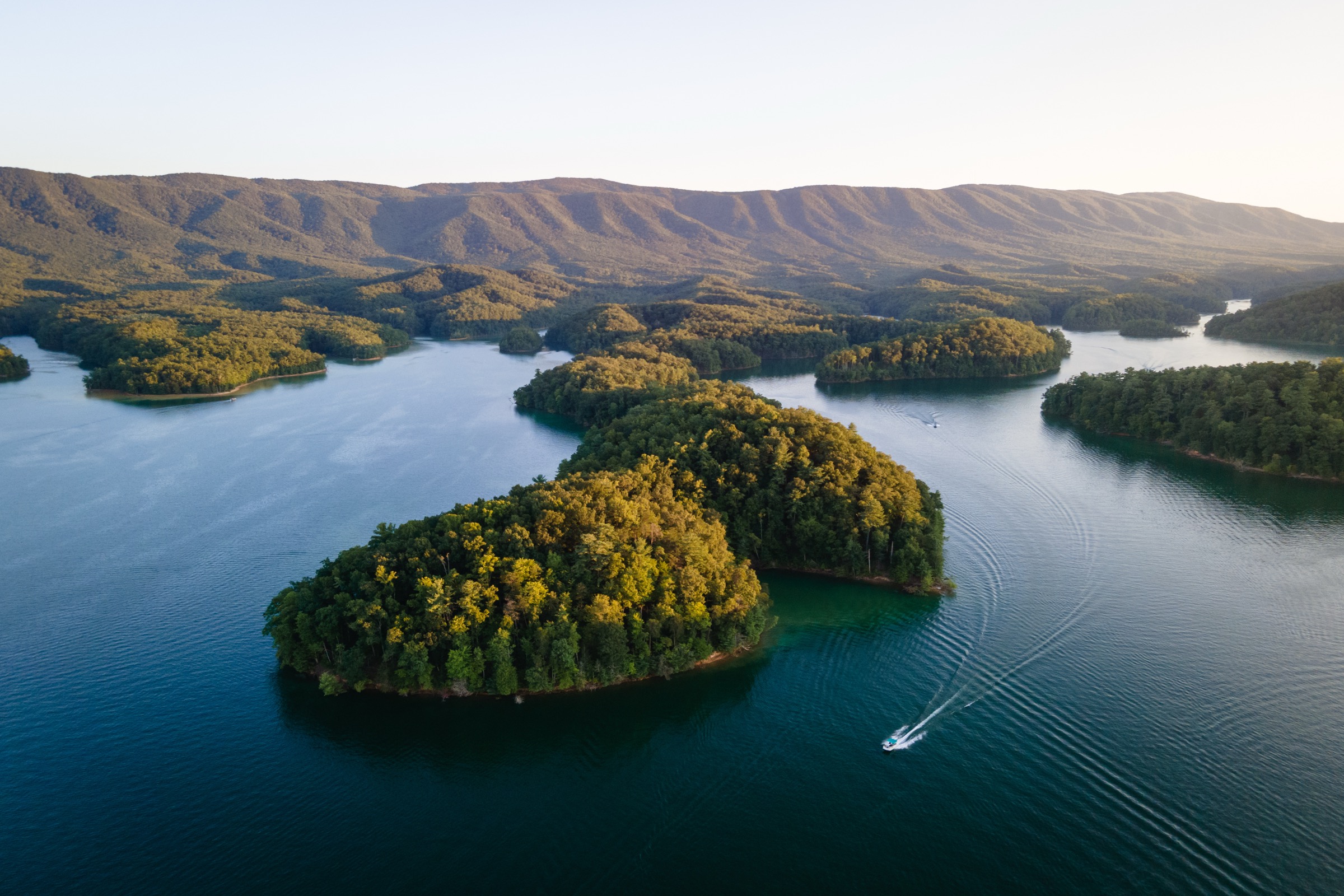 Aerial view of Boone Lake with forested islands and Appalachian Mountains at sunset